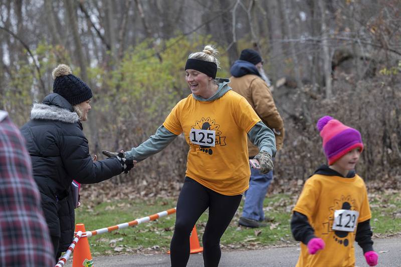 Kayla Halfacre (left), congratulates Autumn Shomaker on her run Thursday, Nov. 28, 2024, during St. Anne’s Turkey Trot 5K.