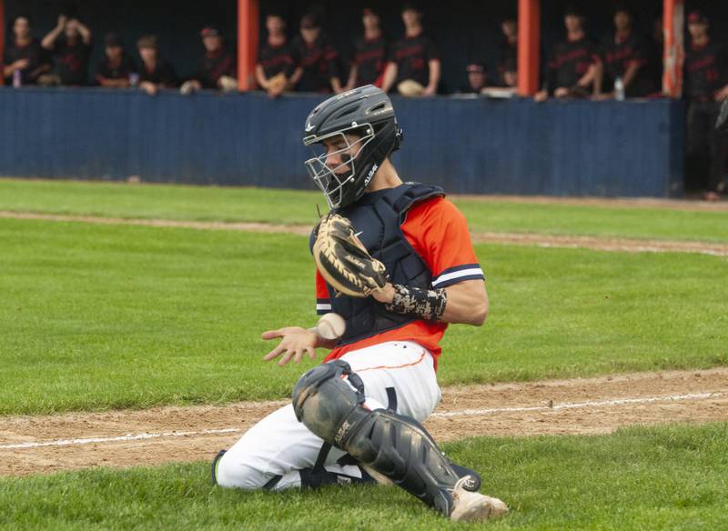 Oswego catcher Tyler Stack fields an errant throw to the plate on a Yorkville score during a varsity boys baseball game on Wednesday, May 18, 2022 at Oswego High School.