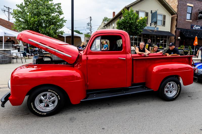 Jim Hrdina, Rachael Moore, and Bill Moore lean on the Moore's 1952 Ford Truck during Plainfield Cruise Night on June 3, 2025.
