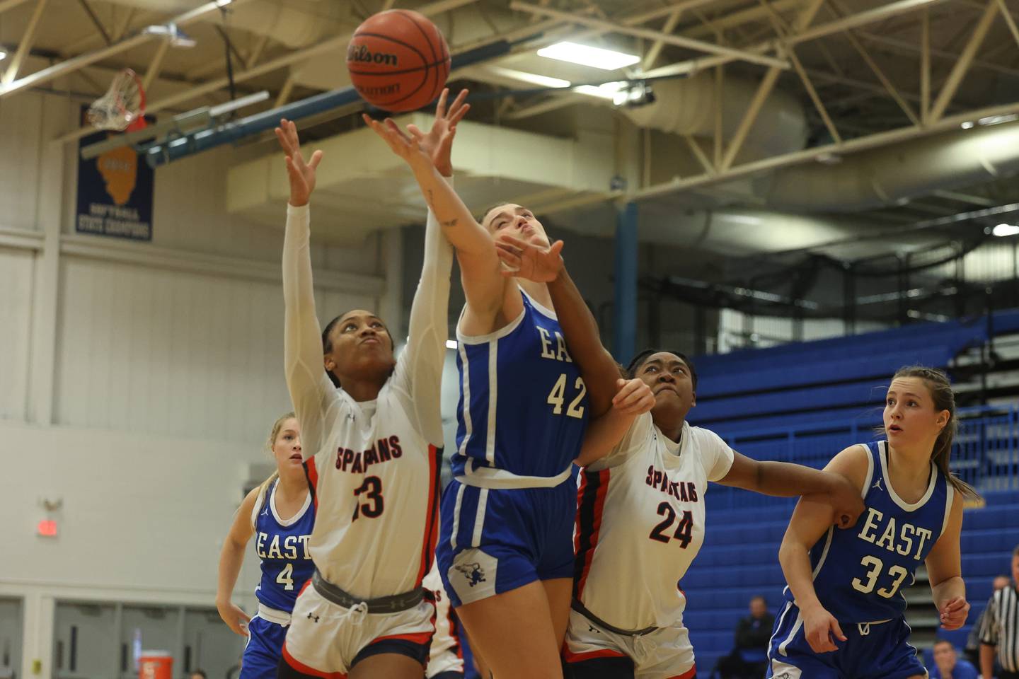 Lincoln-Way East’s Hayven Smith beats out Romeoville’s Jadea Johnson, left, and Serenity Smith for the rebound in the Sandburg Holiday Classic semifinal on Thursday, Dec. 28th, 2023 in Orland Park.