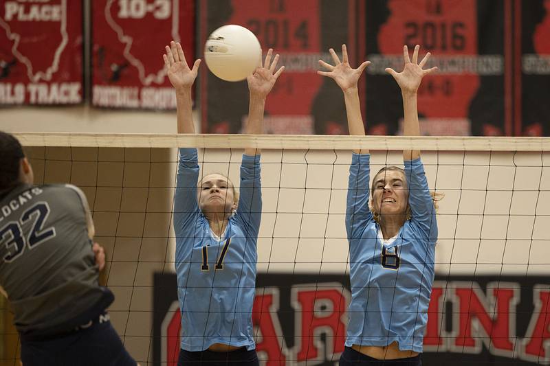 Ottawa Marquette’s Avery Durdan (left) and Mary Lechtenberg go up to block a shot in game one of the Crusader’s sectional semifinal Monday, Oct. 31, 2022 against River Ridge.