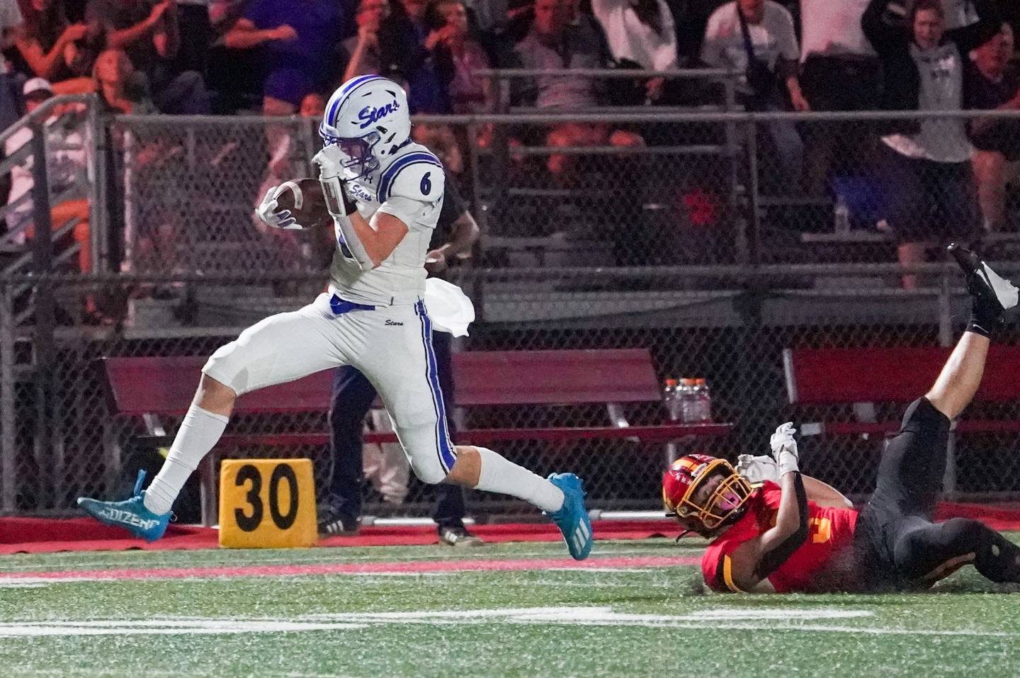 St. Charles North's Keaton Reinke (6) runs after the catch for a touchdown against Batavia's Drew DiBiase (3) during a football game in September 2024 at Batavia High School.