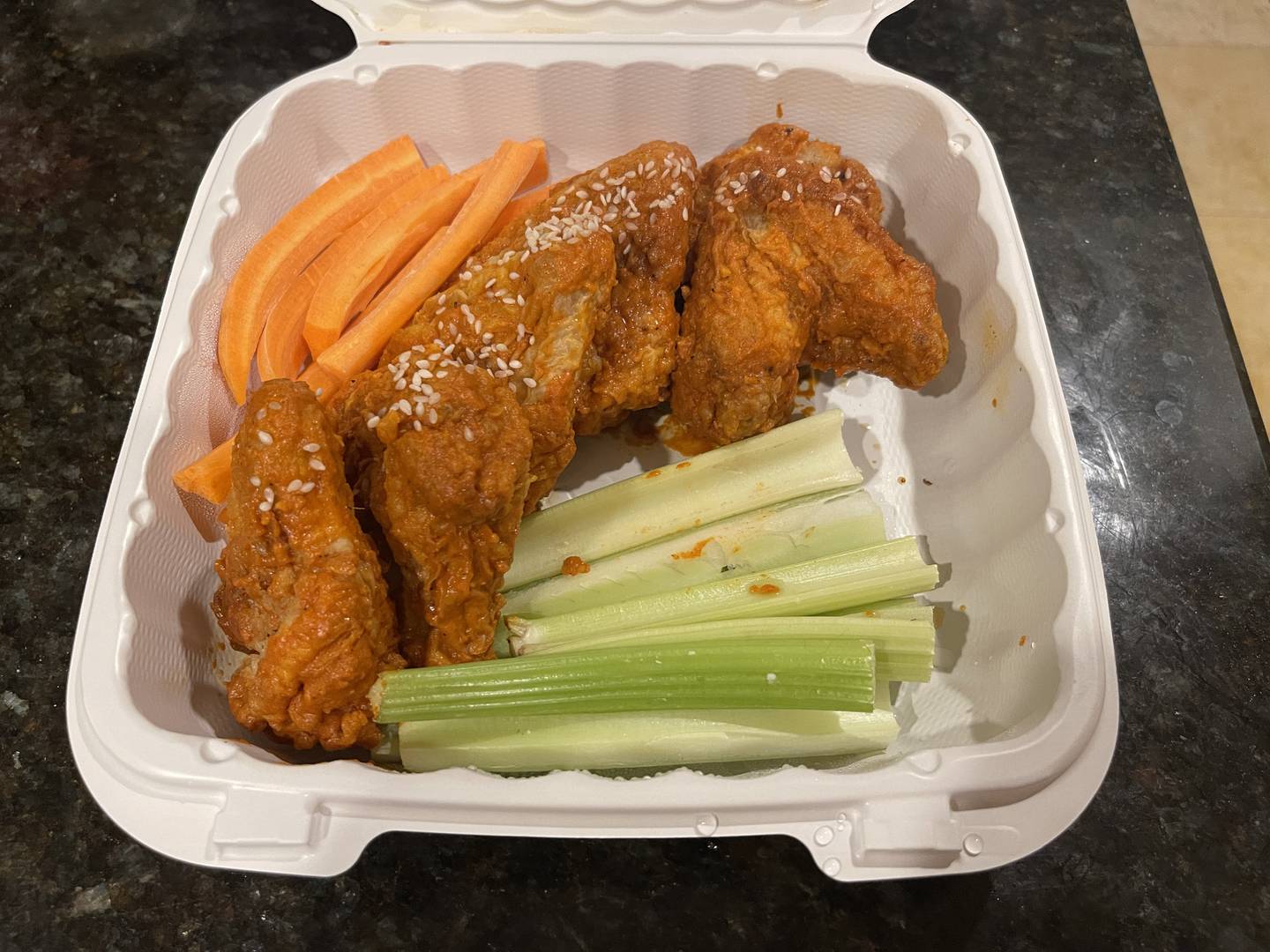 Organic chicken wings with spicy Korean sauce taken to-go from Vine and Plate in Crystal Lake.