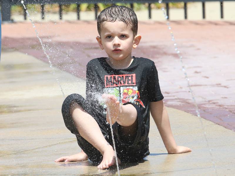 Abbl Cooper of Streator, dips his foot into cold water  on Tuesday, July 1, 2025 while visiting the splash pad at City Park in Streator.