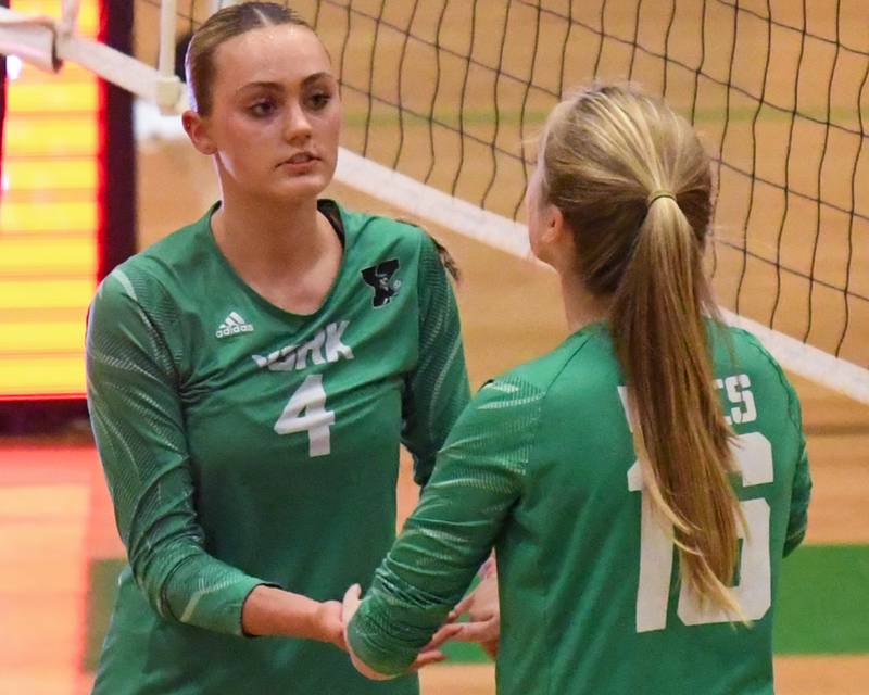 York's katie Day (4) gets congratulated by teammate Audrey Faley (16) after scoring a point during the game on Tuesday Oct. 22, 2024, while taking on Downers Grove North held at York High School in Elmhurst.