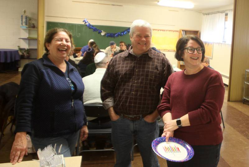 From left, Ellen Morton of Woodstock shares conversation with Tom and Michelle Genzlinger of Crystal Lake and others during a Chanukah party at The McHenry County Jewish Congregation Sunday.