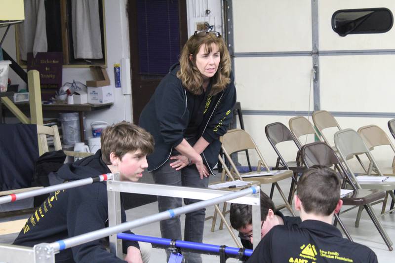 Coach of the McHenry County STEM team The Golden Ration Melissa Ryan talks with two team members before heading to the international competition in Texas.