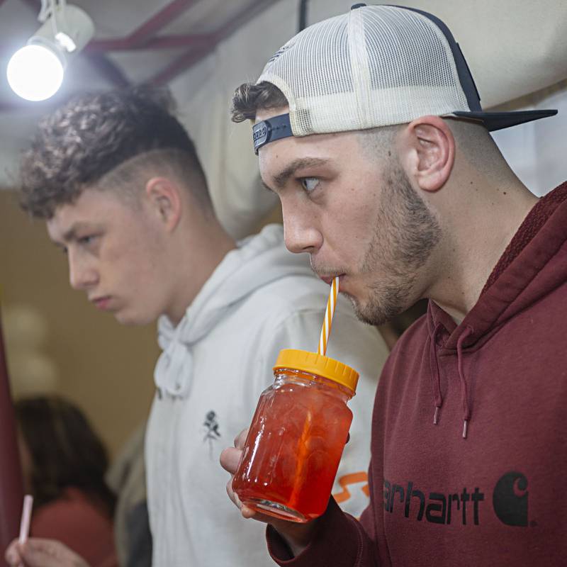 Nate Neubauer, a CEO class alum himself, takes a sip of Kelsey Woolard’s drink Thursday, April 28, 2022 at the WACC CEO trade show in Sterling.