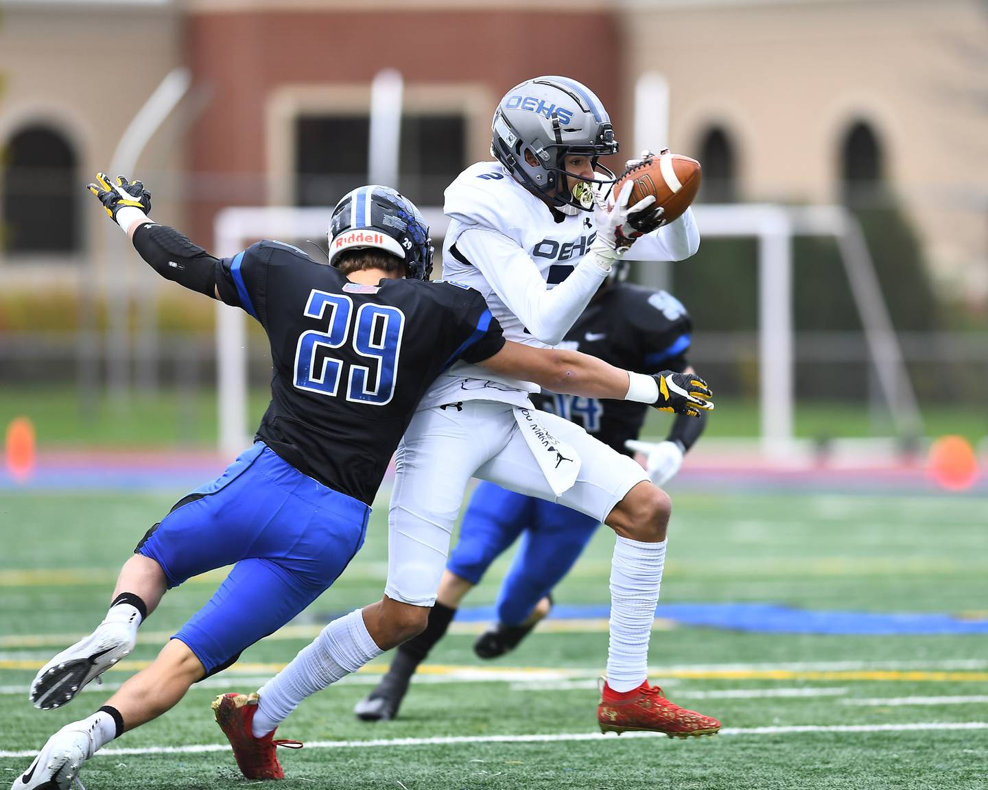 Lincoln-Way East's Dj Ritter (29) wraps up Oswego East's wide receiver Ty Carlson (2) after making the catch on Saturday, Oct. 30, 2021, at Lincoln-Way East High School in Frankfort.
