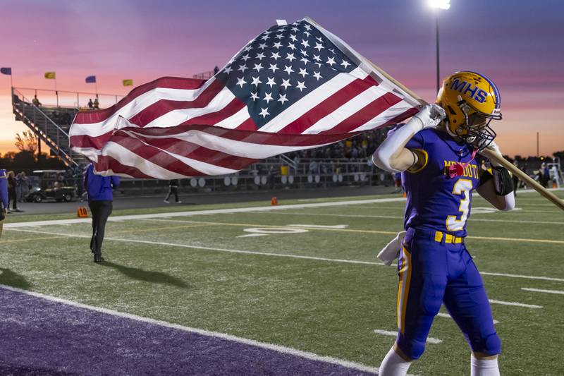 Rhett Watson makes his way out onto the field while flying the American flag before the game against Sherrard at Mendota High School on September 27, 2024.