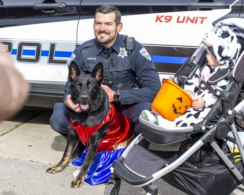 Officer Martin and Halle the dog pose for a picture with a trick or treater at the Plainfield Spooktacular Trick-or-treating event Saturday Oct 25, 2025 in Plainfield.
