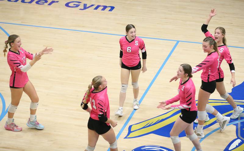 Members of the Serena volleyball team celebrate after beating Marquette in the first set on Wednesday, Oct. 22, 2025 in Bader Gymnasium at Marquette High School.