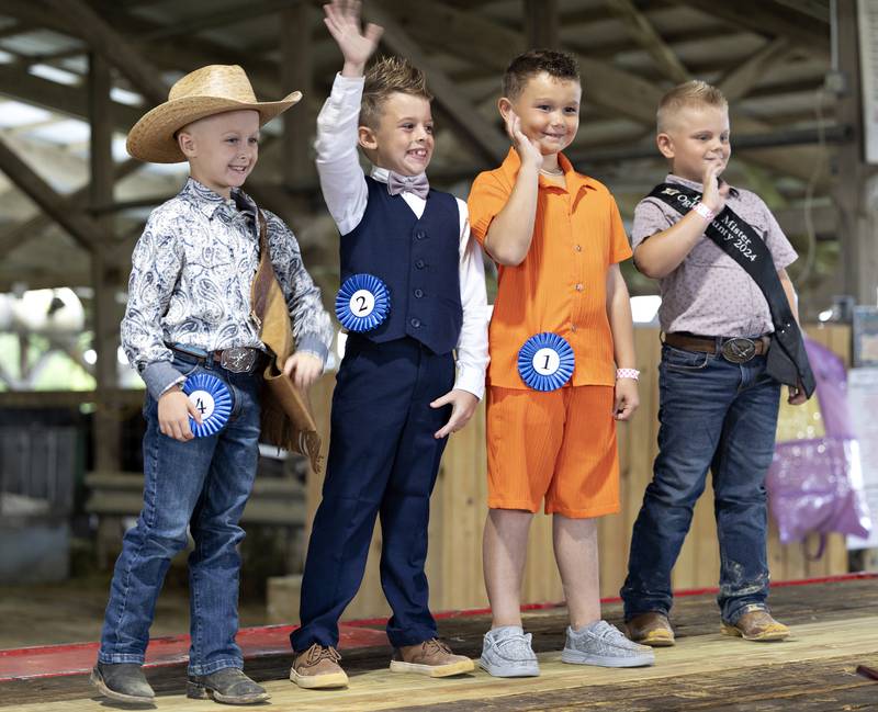 Little Mister Ogle County contestants Ty Johnson (left), Jaxson King and Liam Wright wave from the stage with last year’s winner Kaiser Hauch Thursday, July 30, 2025, at the Ogle County Fairgrounds.