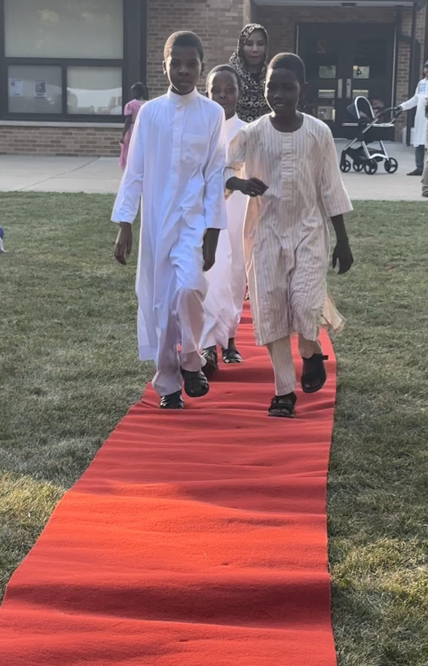 Jefferson Elementary School students in traditional Sudanese clothing walk the red carpet during a fashion show at the school's annual Multicultural Night in DeKalb on Sept. 13, 2024.