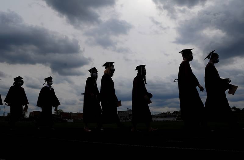 Prairie Ridge High School seniors walk onto the school’s track Sunday afternoon, May 16, 2021, during the second of three commencement ceremonies at Prairie Ridge High School in Crystal Lake. Over 300 students graduated during the ceremonies.