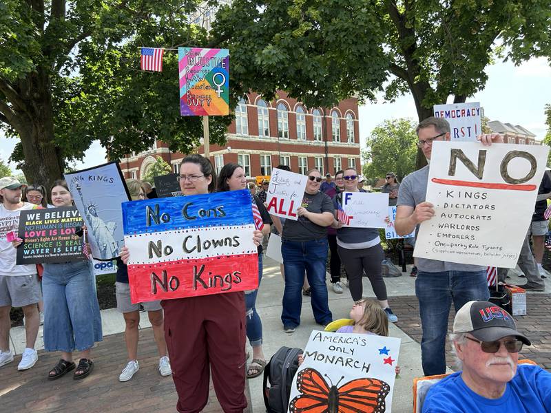 Attendees at the "No Kings" rally held in Oregon, Illinois on Saturday, June 14, 2025 hold their signs critical of the actions by President Donald Trump.
