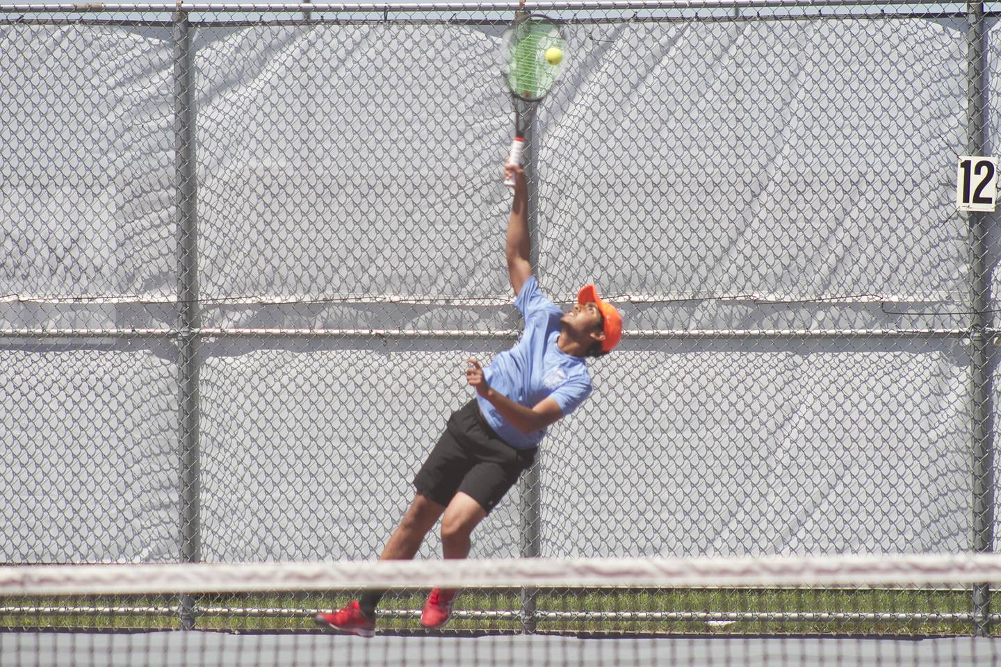Oswego East junior Vivek Parashar sends the ball flying across the court during boys' conference tennis May 26 at Plainfield North High School.
