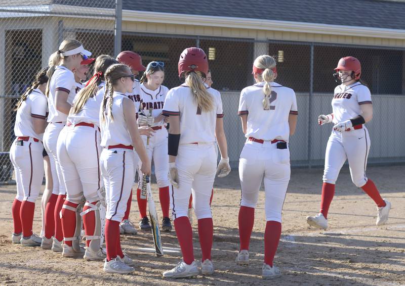 Teammates gather at home plate to congratulate Aubrey Sullivan for her third inning home run Wednesday against Sycamore at Ottawa.