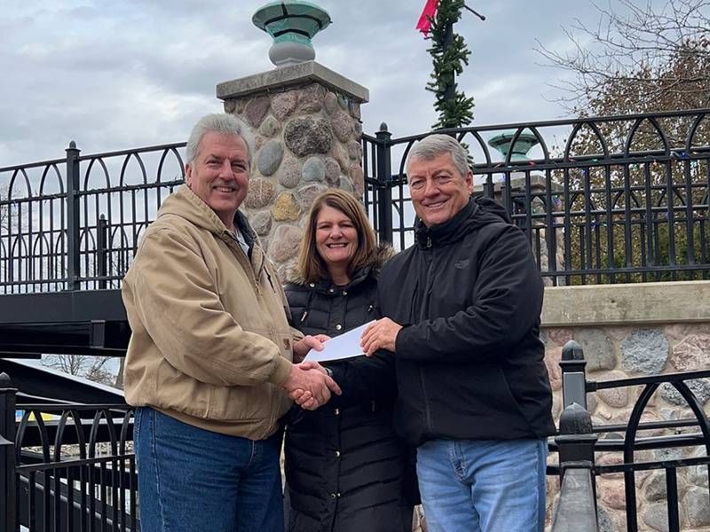 Keith Johnson, left, and Kathy Carey of the A.D. Johnson Foundation present a $10,000 donation check to McHenry Riverwalk Foundation President John J. Smith on Dec. 1, 2022.