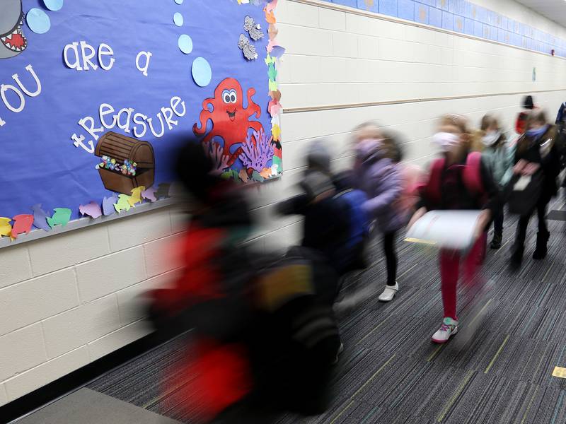 Students head through the hallways to class Monday, Jan. 25, 2021, at Leggee Elementary School in Huntley, during the first day back to hybrid learning for Huntley Community School District 158.