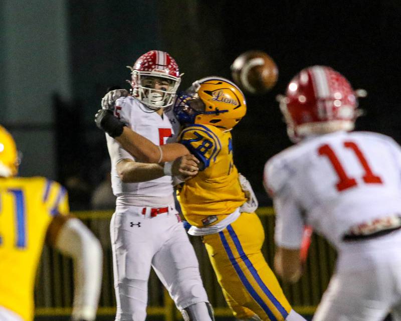 Naperville Central's Sebastian Hayes (5) is hit on throw to Vincent Bern (11) by Lyon's Roman Sosnovyy (78) during Class 8A quarterfinal football game between Naperville Central at Lyons on Friday, Nov 15, 2024  in Western Springs.