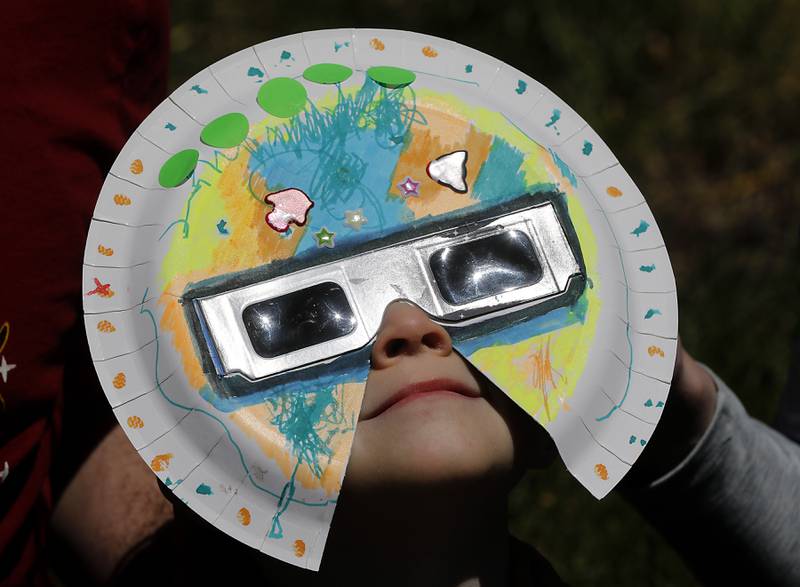 Owen Galiotto, 3, watches the partial eclipse Monday, April 8, 2024, at the Crystal Lake Park District's Nature Center.