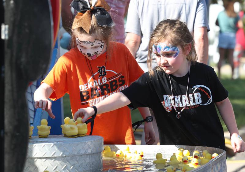 Reese Wachowski, and her sister Rylee, 6, from DeKalb, play a duck game Friday, Aug. 23, 2024, during the DeKalb Corn Fest in downtown Dekalb.