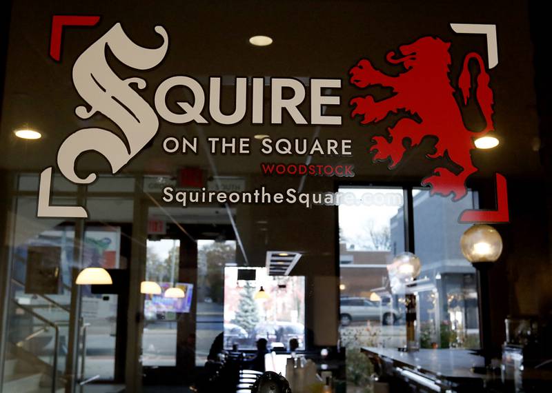 Reflections on the window sign  on Tuesday, Nov. 12, 2024, at Squire on the Square in Woodstock. The restaurant, which has similar decor as other Village Squire restaurants, is a joint venture between the Linardos family and Bob Karas of Karas Restaurant Group.

Squire on the Square is located in the basement of the Old Courthouse in Woodstock, and its menu will features items similar to the Linardos family’s restaurants and the Village Squire.  

The eatery replaces the Public House that closed at the end of March.