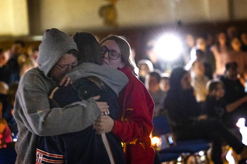 Mourners comfort one another during a candlelit vigil Sunday, March 31, 2024 in Tampico for the three high school victims of a car accident.