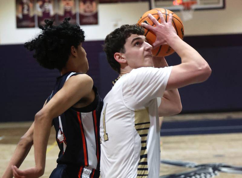 Hiawatha’s Jackson Davenport shoots in front of DePue’s Diego Perez during their game Tuesday, Jan. 20, 2026, at Hiawatha High School in Kirkland.