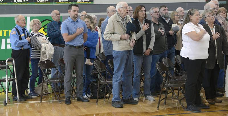 Veterans attending the special Veterans Day ceremony at Seneca High School Monday,stand during the Pledge of Allegiance.