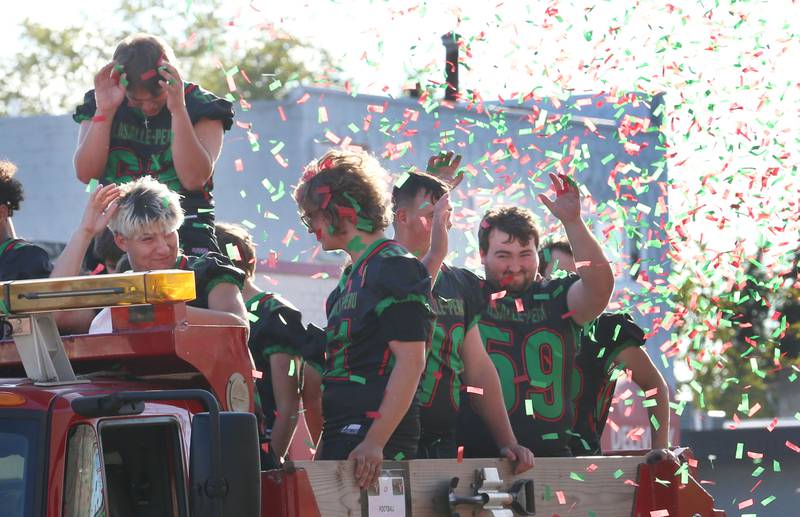 Members of the L-P football team are covered in red and green confetti during the L-P Homecoming parade on Thursday, Sept. 26, 2024 downtown La Salle.