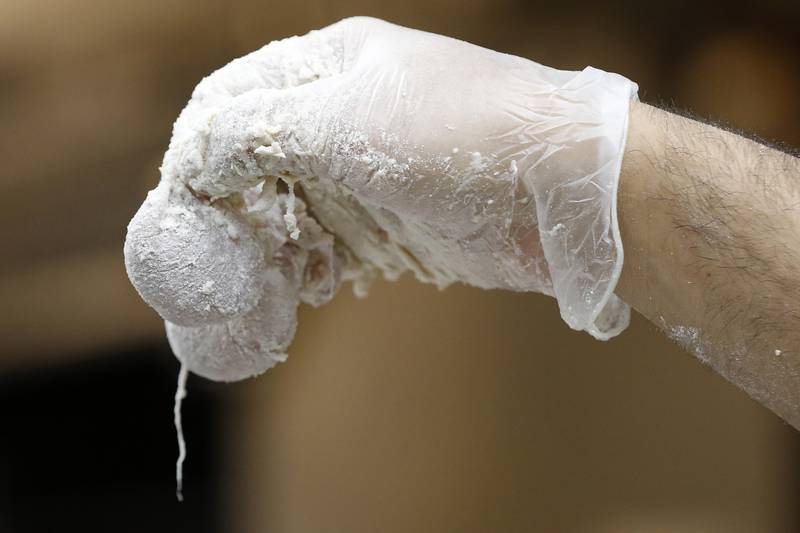 Parkside Pub cook Alfredo Andrado holds up a pair of turkey testicles coated in flour prior to deep frying during the 39th annual Turkey Testicle Festival at Parkside Pub on Wednesday, Nov. 24, 2021, in Huntley.