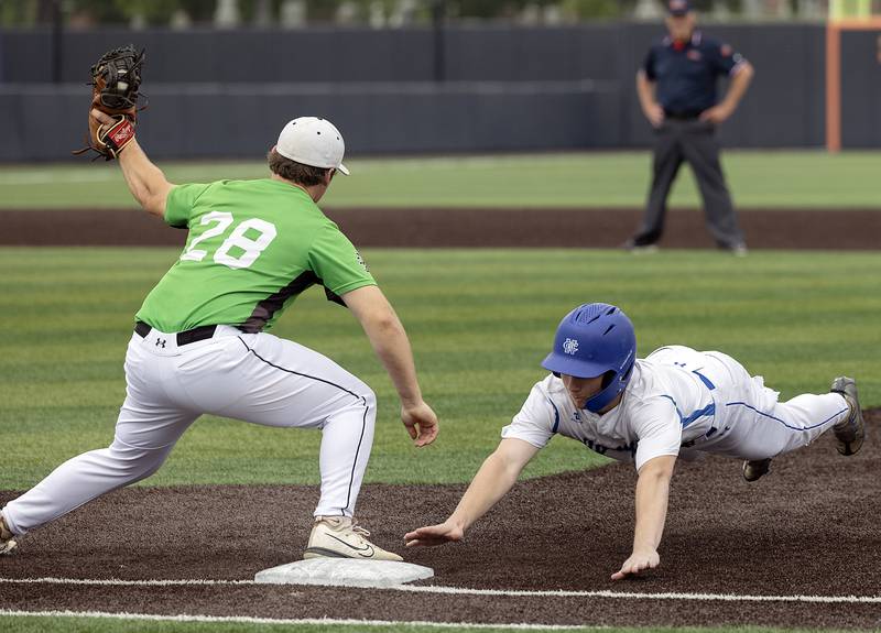 Newman’s Ashton Miner dives back to first on a pick off play against Eureka Saturday, June 7, 2025, during the Class 2A state baseball third place game at Illinois Field in Champaign.