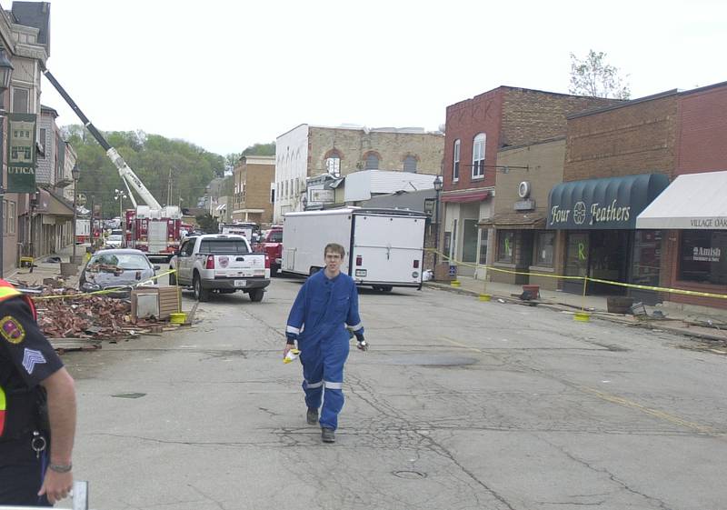 Ben Brown future Utica Fire Chief walks down Mill Street the day after the tornado on Wednesday, April 21, 2004
