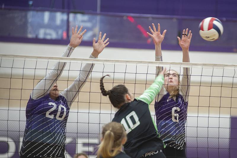 Dixon’s Olivia Cox (left) and Elexa Varden go up to block Alleman’s Iris Reynolds Wednesday, Sept. 7, 2022.