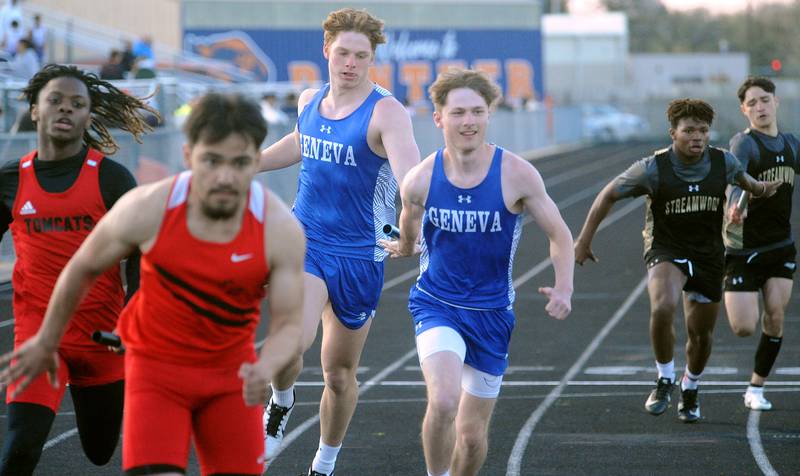 Geneva's Charlie Faith hands the baton to teammate Logan Weber in the varsity 4x200 Meter Relay during the Roger Wilcox Invitational at Oswego High School on Friday, Apr. 28, 2023.