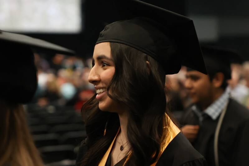 A graduate smiles as she enters the Joliet Junior College Commencement Ceremony on Friday, May 19, 2023, in Joliet.