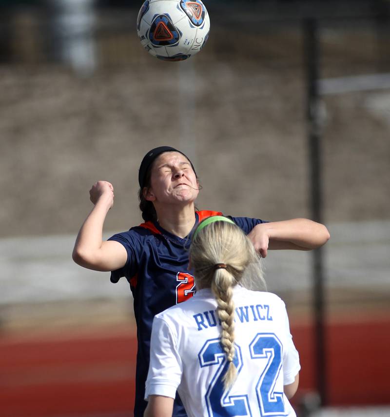 Oswego’s Cameran Guzman heads the ball in front of Geneva’s Morgan Rudowicz during a Naperville Invitational game at Naperville Central on Saturday, April 23, 2022.