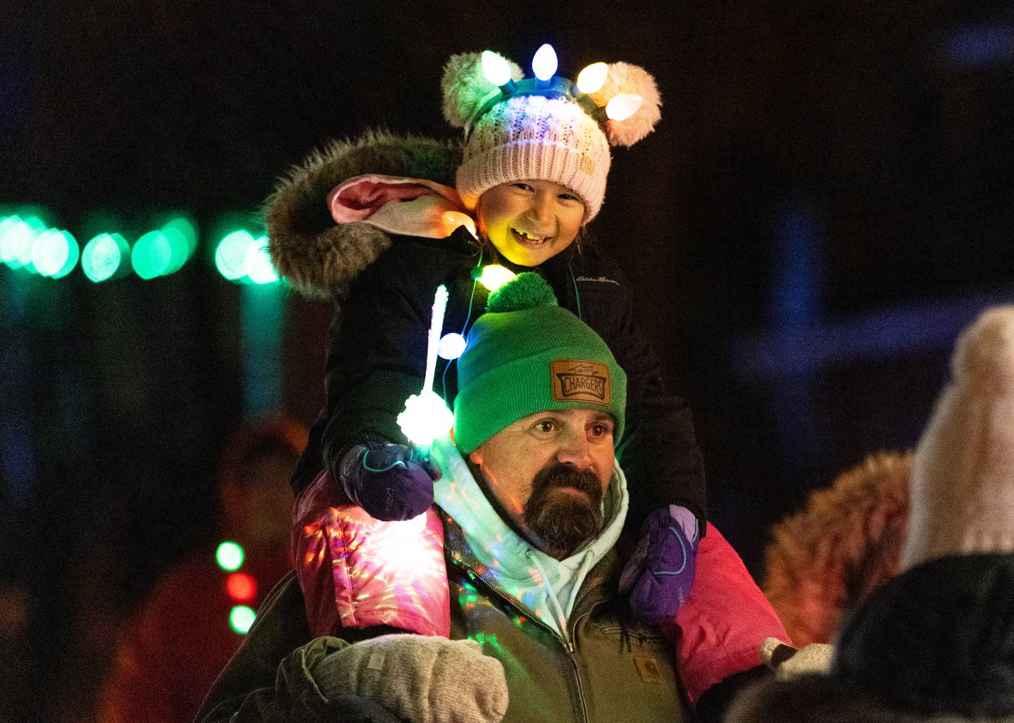 Isley Anderson, 8, and Josh Harman process down Main Street with Colonial Cafe’s float in the St. Charles Holiday Homecoming Electric Christmas Parade on Saturday, Nov. 30, 2024.