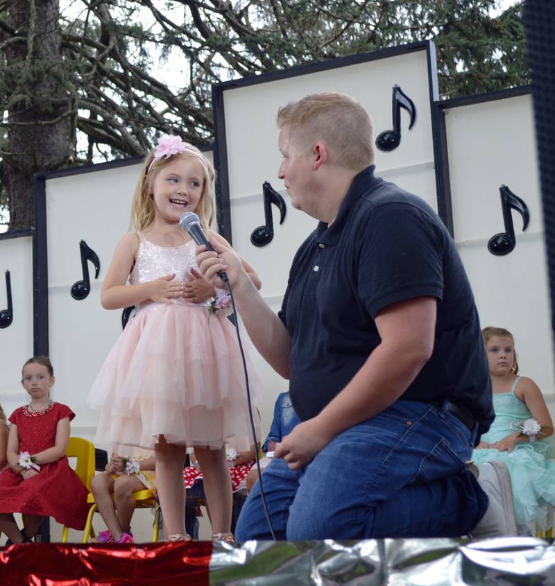 Addison Metzger, 5, of Leaf River, introduces herself during the 2022 German Valley Little Miss and Mister pageant while host Colin Rust, a German Valley native, holds the microphone. Addison was crowned the 2022 Little Miss at the end of the July 16 competition, which took place at Ben Miller Park as part of German Valley Days. There were 10 girls vying for the title.