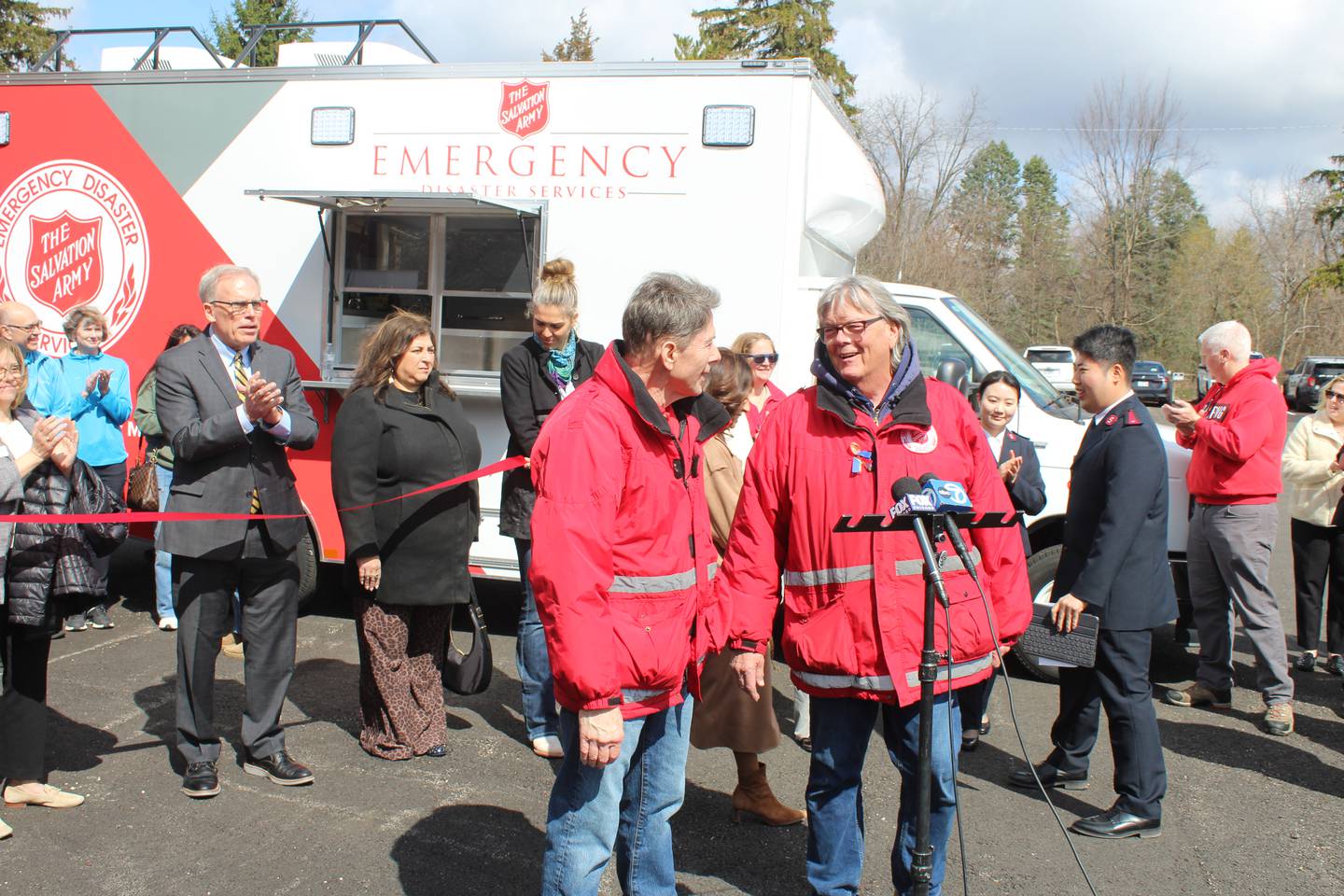 Salvation Army Emergency Disaster Services volunteers Tomm Allen (left) and Pat Trunda speak during the ribbon-cutting ceremony for the new emergency canteen on April 6, 2026, in Crystal Lake.