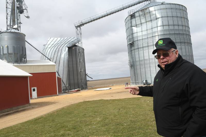 Jim Ludwig of Lanark points to the 125-foot grain bins that were damaged during Friday's storm along Illinois 64 about 5 miles east of Lanark.