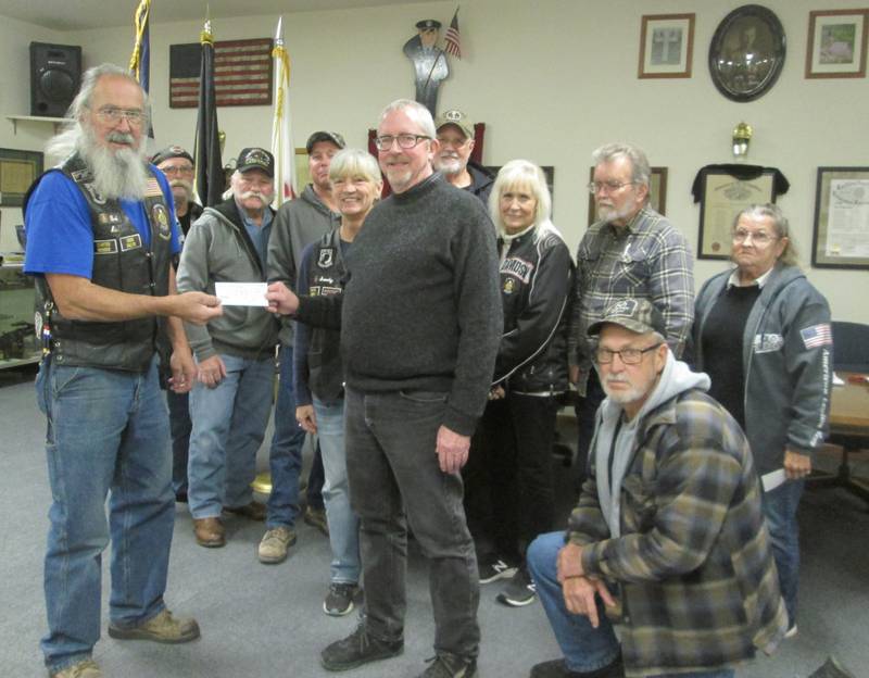 Pictured left is Bob Lawrence, American Legion Riders director, presenting a check to Plano Rockin’ Christmas President Mike Rennels along with American Legion Riders Post #181 from Sandwich members Rich Arnett, Cliff Oleson, Adam Arnett, Sandy Lawrence, Bob and Cherie Mauer, Henry Herbst, Bill Kolb (kneeling) and Sally Kolb.