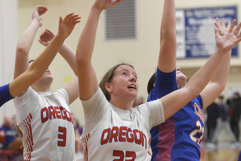 Oregon's Lola Schwarz (3) and Aniyah Sarver (23) reach for a rebound along with Genoa-Kingston's Regan Creadon (22) on Friday, Jan. 30, 2026 at the Blackhawk Center.