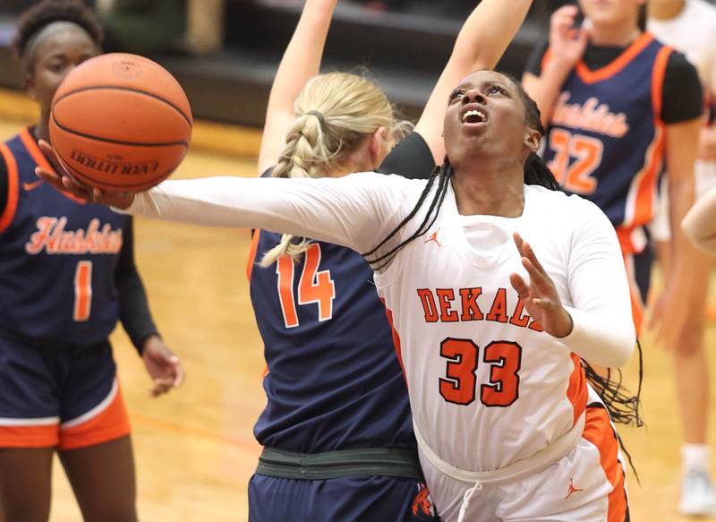 DeKalb’s Cayla Evans gets a shot off behind Naperville North's Kendall Johnson Monday, Jan. 22, 2024, during their game at DeKalb High School.