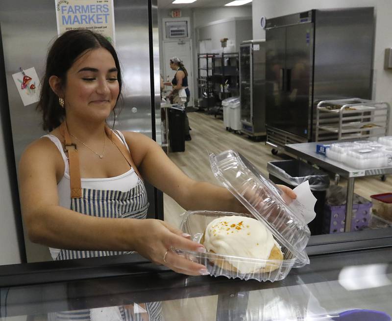 Emmie Picchi packages a cinnamon roll for a customer on Friday, June 27, 2025, at the recently opened Black Market Bakery in downtown Crystal Lake.