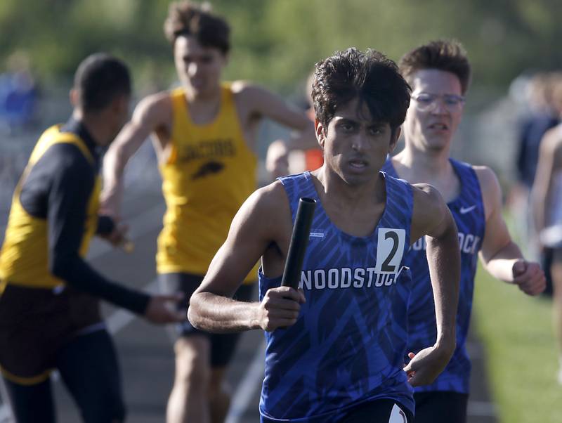 Woodstock’s Ishan Patelon takes off after getting the baton for the last leg of the 4 x 800m meter relay on Friday, April 19, 2024, during the McHenry County Track and Field Meet at Cary-Grove High School.