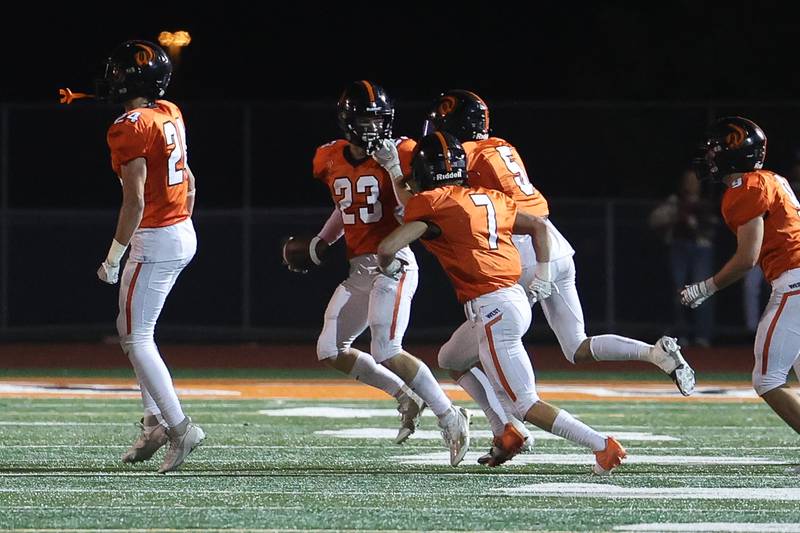 Lincoln-Way West’s Ryan Stiglic is mobbed by teammates after an interception against Bolingbrook on Friday, Sept. 22 in New Lenox.