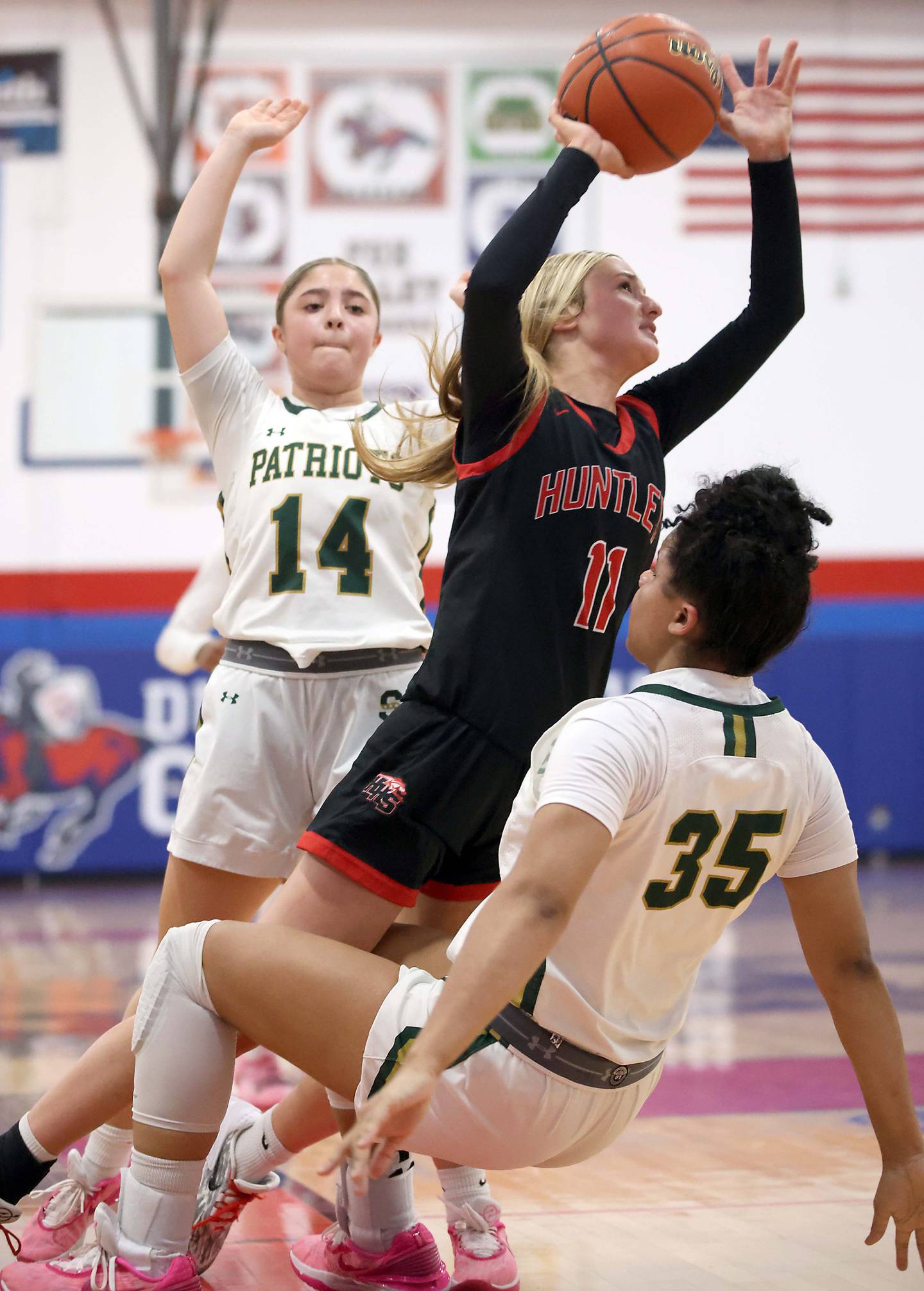 Huntley's Anna Campanelli (11) splits Stevenson's Emma Brooks (14) and Emory Klatt (35) on her way to the hoop Wednesday, Dec. 27, 2023 at the 40th Annual Komaromy Classic at Dundee-Crown High School in Carpentersville. Campanelli was given a charging foul.
